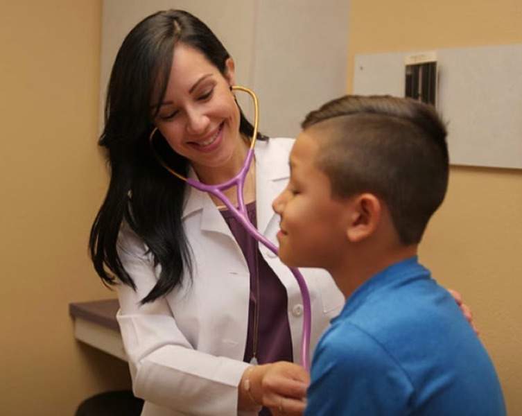 a female doctor doing a checkup on a little boy