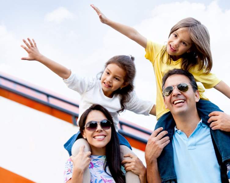 happy parents with their kids riding on their shoulders